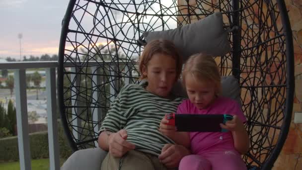 Ikatan Saudara Atas Game Konsol Portabel Kursi Ayunan Balkon Tahun — Stok Video