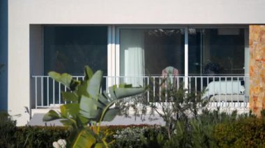 LS - balcony of a house in Portugal with lush vegetation and palm trees in the foreground