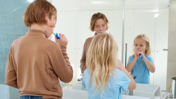 Siblings Brushing Teeth Together Using Electric Toothbrushes — Stock Video