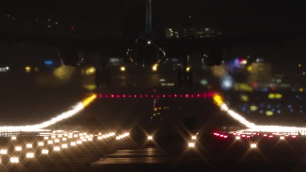由跑道明亮灯光照亮的慢动作视频 其特点是飞机从后面着陆的黑暗轮廓 — 图库视频影像