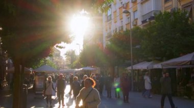 SEVILLE, SPAIN - 3 HAZİRAN 2023: İnsanlar Seville, İspanya sokaklarında sakin bir yürüyüş yapıyor, batan güneşin sıcacık parıltısında güneşleniyorlar