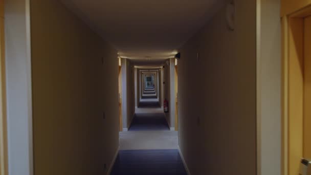 沿着一个有黄色门牌号的空荡荡的旅馆走廊走着 — 图库视频影像