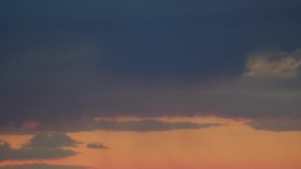 黄色の夕日の空と暗い雲を背景に 飛行機は順番になっています そのナビゲーションライトが点滅しています — ストック動画