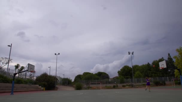 一名身穿运动服的孤家寡人正在球场上练习打篮球 — 图库视频影像