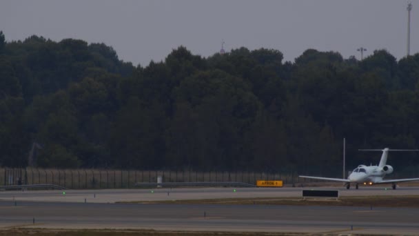 空港滑走路からの離陸のための日没の滑走路へのプライベートジェットタクシー — ストック動画