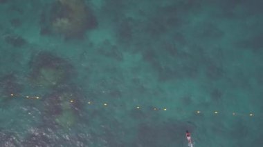 Koh Tao üzerinde renkli gün batımı, okyanusta tekneler. Şnorkelle yüzen üst manzara canlı kıyı şeridini, çarpıcı deniz manzarasını gösteriyor..