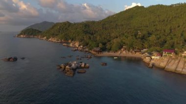 Tayland adası sahilinde güzel bir gün batımı. Okyanusta yüzen tekneler ve çarpıcı sahil şeridi..