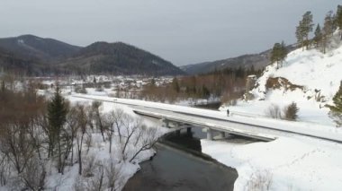 Rusya, Sibirya 'daki kış manzarası nefes kesici. Karla kaplı tarlalar, ormanlar, dağlar ve güzel bir köprü. Sakin nehir ve dolambaçlı yol manzaranın güzelliğini arttırır. İdeal