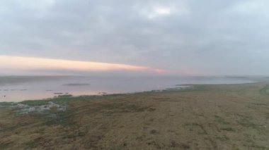 Sisli Sibirya Gölü üzerinde puslu bir sabah. İnsansız hava aracı tarafından yakalanan dingin güzellik. Orman ve su yoğun sisle kaplıydı. Gün doğumu sıcaklık ekler.
