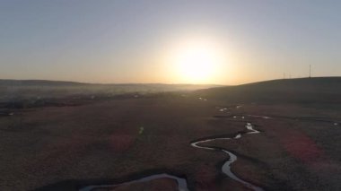 Bahar zamanı Sibirya 'da yemyeşil yemyeşil bir nehrin nefes kesici manzarası, bulutların arasından güneş ışınları yayılıyor. Doğa güzelliğinin en iyisi..