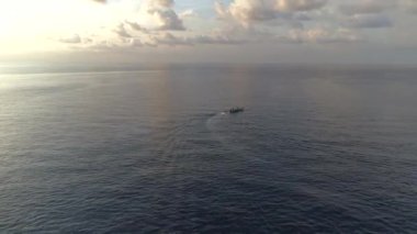 Koh Tao üzerinde renkli gün batımı, okyanusta bulutlara karşı yelken açan tekneler ve güzel sahil şeridi..