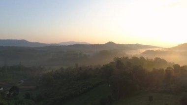 Chiang Mai, Tayland 'daki Doi Inthanon Ulusal Parkı' nın nefes kesici manzarası. Güneş ışınları yemyeşil ormanları ve görkemli dağları aydınlatarak büyüleyici bir manzara yaratır. Bu sakin köyü keşfedin.