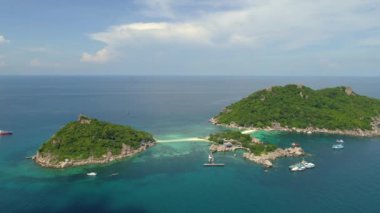 Tayland 'da tropikal bir adada çarpıcı bir gün batımı. Kıyı şeridinde yüzen tekneler gibi canlı renkler gökyüzünü dolduruyor. Deniz ve sahil manzaralı nefes kesici bir cennet kaçamağı..