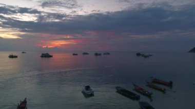 Renkli bulutlar ve teknelerle denizin üzerinde güzel bir gün batımı. Tayland, Koh Tao 'da sakin bir sahil. Tatil kaçamağı için mükemmel..