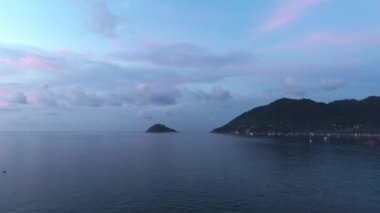 Canlı renklerle nefes kesici Tayland gün batımı, sakin okyanus, gemiler, bulutlar ve adalar.