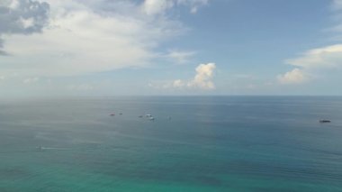 Mavi denizde yüzen renkli teknelerle ve güzel bir sahil şeridiyle Koh Tao 'nun üzerinde göz kamaştırıcı bir gün batımı..