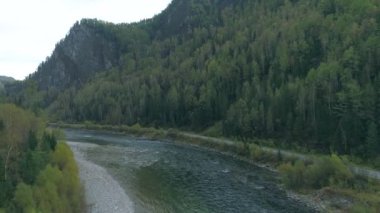 Rusya, Hakassia 'daki sonbahar manzarası. Çarpıcı orman, dağlar, huzurlu nehir. Sibirya Taiga 'sının güzelliğini yakalıyor. Tuva 'daki seyahat meraklıları için mükemmel..