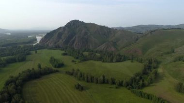 Sibirya 'da yeşil bozkır, Hakassia nehri ve Abakan şehri ile sisli yaz manzarası. Seyahat aşıkları için ideal.