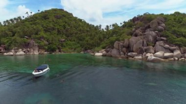 Muhteşem dağ manzaralı ve kayalık şekilli mercan gölü kıyıları. Koh Tao 'daki Özgürlük Sahili' nin berrak sularında maskeyle yüzmenin ve şnorkelle yüzmenin tadını çıkar..
