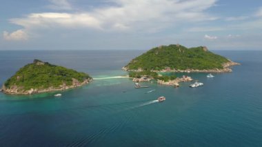 Koh Tao 'nun renkli kıyı şeridi boyunca giden tekneler Tayland sahilinde güzel bir manzara yaratıyor..