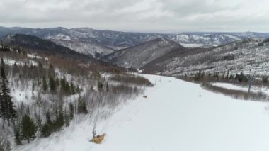 Sayanogorsk, Sibirya 'da kayak, nefes kesen karlı bir orman ve dağ manzarasında heyecan verici bir kış sporları deneyimi..