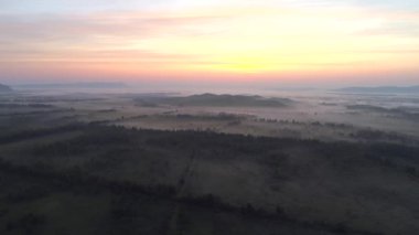 Rusya, Hakassia 'da sisli bir gün doğumu. Görkemli dağlar ve kayalık arazi Sibirya 'da çarpıcı bir doğal anıt oluşturur..