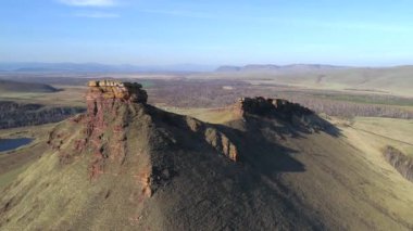 Rusya, Hakassia 'daki Sibirya Stonehenge' inin hava görüntüleri. Çarpıcı dağ manzarası, mavi gökyüzü, yeşil bozkır. Gizemli antik kaya oluşumu.