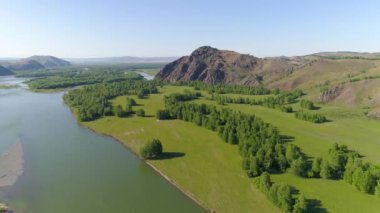 Akan bir nehirle yaz manzarasının göz kamaştırıcı bir görüntüsü. Canlı renkler Hakasya 'da kırsal kesimi canlandırıyor.