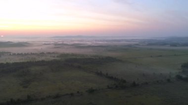 Sisli vadide büyüleyici bir gün doğumu sisle kaplı manzaranın dingin güzelliğini gözler önüne seriyor. Khakassia yeşil bozkırları ve dağ sırtı sandıkları nefes kesici görünüyor. Manzaralı ve el değmemiş Sibirya doğası