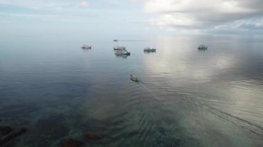 Renkli gemilerin ortasında, Tayland 'daki Tao Adası' nda okyanus ve günbatımı güzelliğini yakalıyorlar..