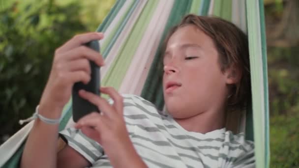 Close Adolescente Relaxado Uma Rede Navegando Smartphone — Vídeo de Stock