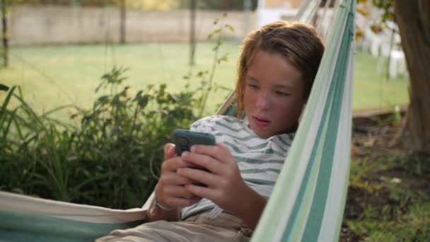 Jovem Rede Engajado Com Seu Smartphone Ambiente Tranquilo Jardim — Vídeo de Stock