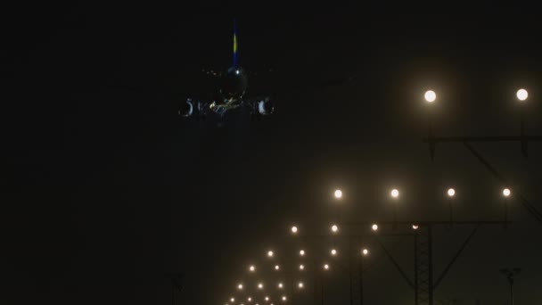 飛行機は夜空に降下し 着陸装置はランウェイアプローチライトと整列し 空港に着陸する準備ができています — ストック動画