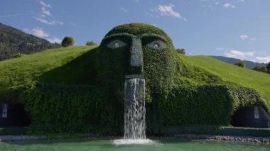 WATTENS, AUSTRIA - 13 Temmuz 2023: Avusturya 'daki Swarovski Müzesi' nde şelale ağızlı ve ulaşılabilir geçitli yeşil heykel