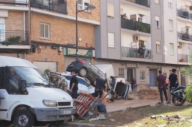 VALENCIA, İSPA 31 Ekim 2024: İspanya 'nın Valencia kentinde meydana gelen şiddetli sel felaketinin ardından hasar araştırması yapan vatandaşlar ve işçiler, yıkılan araçlar ve enkazlar felaketlerin etkilerini vurguluyor