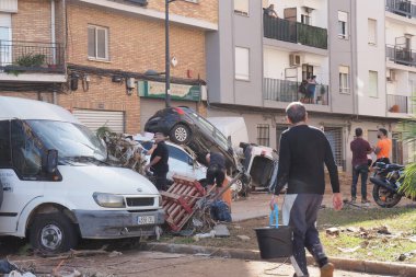 VALENCIA, İSPA 31 Ekim 2024: Valensiya, İspanya 'da meydana gelen şiddetli sel felaketinin ardından vatandaşlar ve acil durum personeli, araçların devrilmesi ve sokaklara saçılmasıyla hasar tespiti