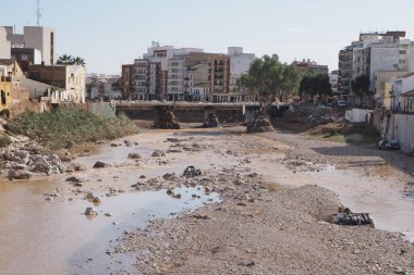 VALENCIA, İspanya 31 Ekim 2024: Valencia, İspanya 'da meydana gelen şiddetli sel sonrası enkaz ve kayalarla dolu çamurlu nehir yatağı, doğal afetlerin yıkıcı etkisini vurguluyor.