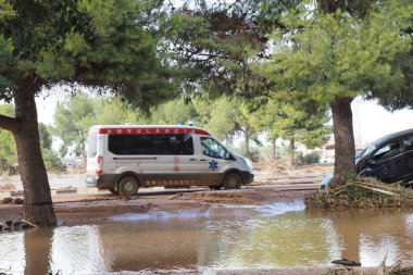 VALENCIA, İSPA 31 Ekim 2024: Valensiya 'da sağanak yağış ve sel sonrası acil sağlık hizmetleri sunan, sel basmış yolda ambulans kullanan sağlık görevlileri