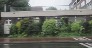Amsterdam 'da yağmurlu günler gösterişli arabalar ve yayalar şehrin büyüleyici mimarisi arasında ıslak sokaklarda geziniyorlar.