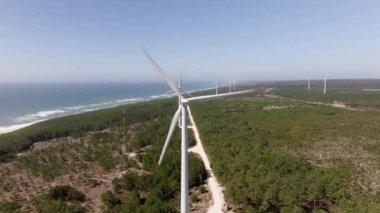Bir kıyı şeridi yakınında dönen rüzgar türbini temiz enerji üretir, sürdürülebilir bir geleceğe katkıda bulunur ve çevreyi korur
