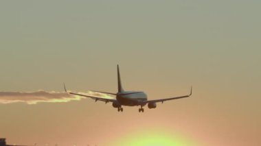 Gün batımında iniş takımları açık bir şekilde piste yaklaşır.