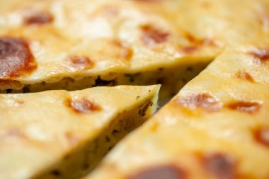 Close-up of a sliced traditional Russian pie with a golden brown crust highlighting its rich texture and filling clipart