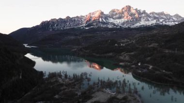 İspanyol Pireneleri 'nde nefes kesici bir sıradağ olan Pena Montanesa, Ibon de los Banos' un sakin sularına gün doğumunda ılık ve pembe bir parıltı saçar.