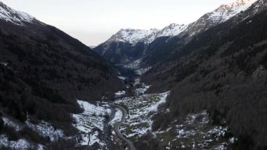 Hava görüntüsü - Karlı manzara Pyrenees Ulusal Parkı 'nı silip süpürüyor, ormanlık yamaçların altındaki vadiyi kesiyor karla kaplı dağ zirvelerine doğru yükseliyor