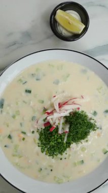 Dikey görüntüler Okroshka, kvass veya kefir temelli soğuk bir çorba, Borscht, canlı bir pancar çorbası, ve Rassolnik, lezzetli bir turşu çorbası, geleneksel Rus mutfağından oluşan lezzetli bir üçlüyü temsil ediyor.