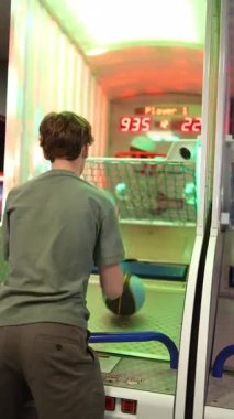 Genç bir çocuk renkli ışıklar altında basketbol oynarken arkadan çekim yapmış.