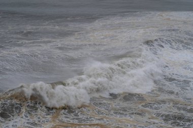 Fırtınalı deniz dalgaları bulutlu bir günde çarpışır ve köpürerek doğanın dramatik ve güçlü ham enerjisini yaratır.