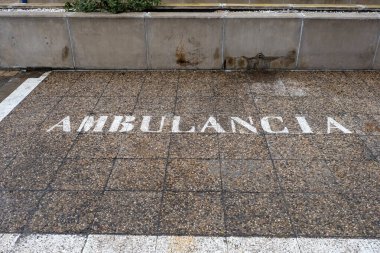 Hastanenin acil durum bölgesi beyaz ambulans parketme işareti ile belirtilen tıbbi araç alanı hızlı hasta taşımacılığı ve kritik bakım erişimi