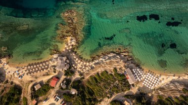 Yunanistan 'ın Toroni kentinin kumlu sahillerini süsleyen deniz şemsiyeleri güzel sahil şeridini ve berrak turkuaz sularını gözler önüne seriyor.