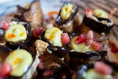 Nar tohumları ve pürüzsüz beyaz sos içeren patlıcan ruloları, zarif Akdeniz 'e özgü aperatif hazırlığı sunar.